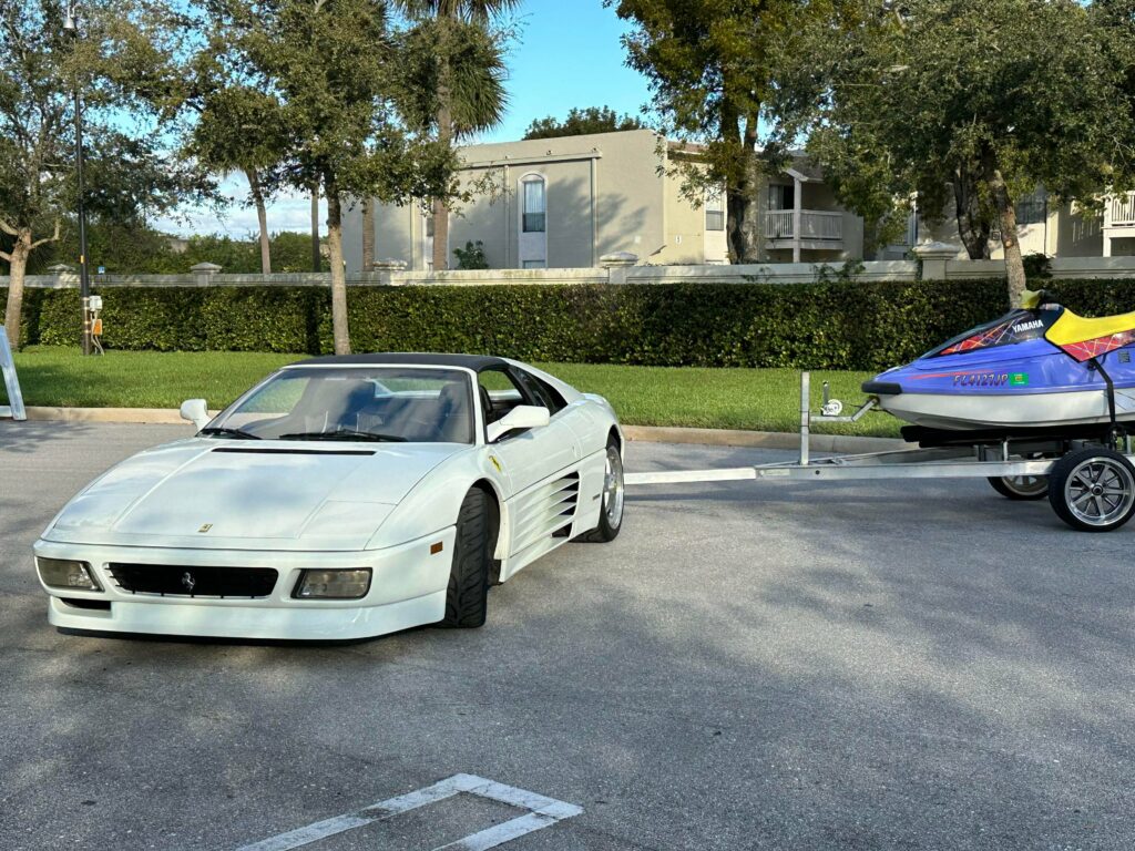 A white [Ferrari 348 TS] pulling a Yamaha wave runner