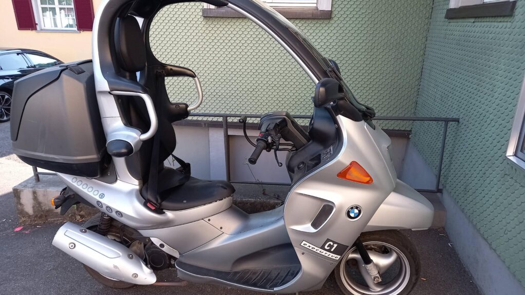 BMW C1. If you use the seatbelt you're allowed to ride without a helmet