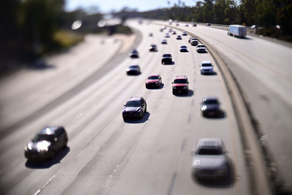 Cars travel in light traffic on the Eastbound 134 freeway in Pasadena California. Cars appear miniaturized.