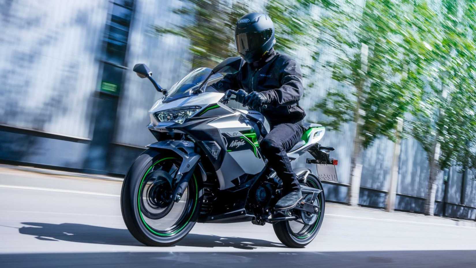 Front action shot of 2024 Kawasaki Ninja E-1 electric sports bike on urban streets.