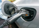 FILE - A hybrid electric vehicle gets charged up. PCEF community grant funds support energy efficiency and transportation infrastructure, as well as other climate response efforts.
