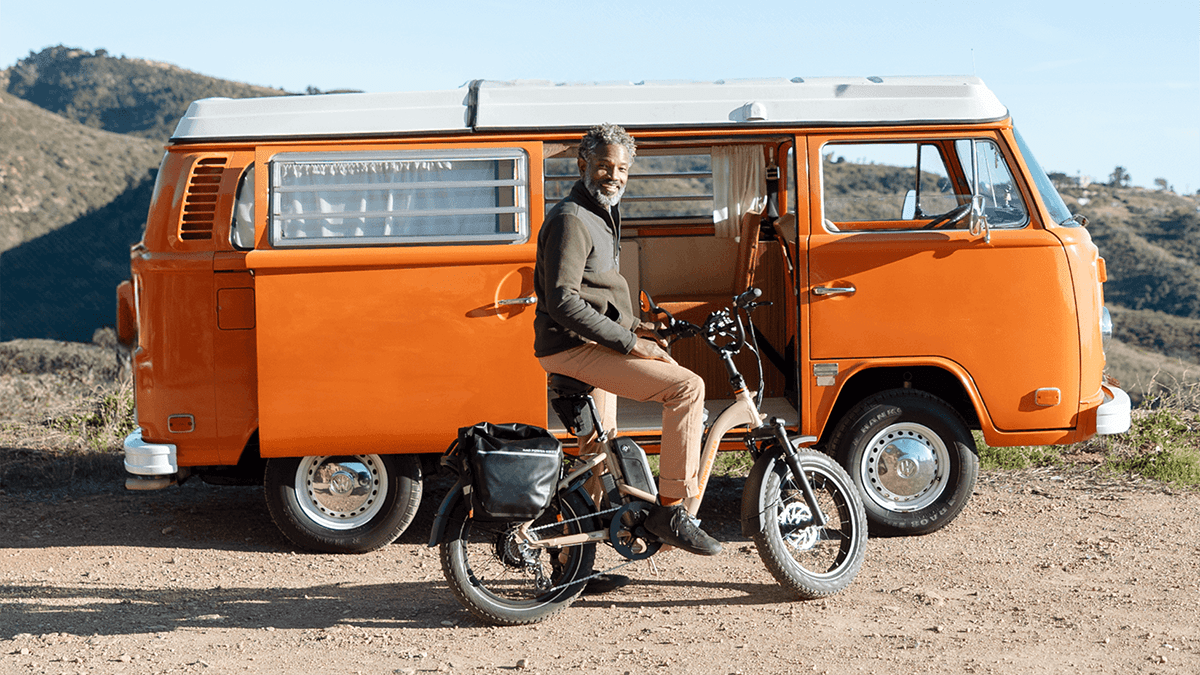 A man sitting on a bicycle next to a van