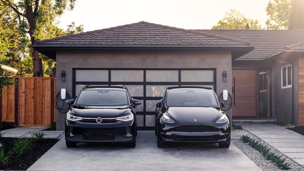 Tesla universal wall connector EV chargers installed at home driveway with two vehicles parked