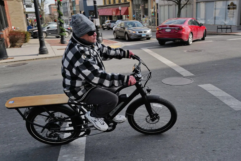 In this file photo, a man is seen riding an e-bike rides onto Union Street in downtown New Bedford. Dartmouth officials say they want to boost public awareness when it comes to the rules on e-bikes, motorized bikes and other small vehicles of the like.