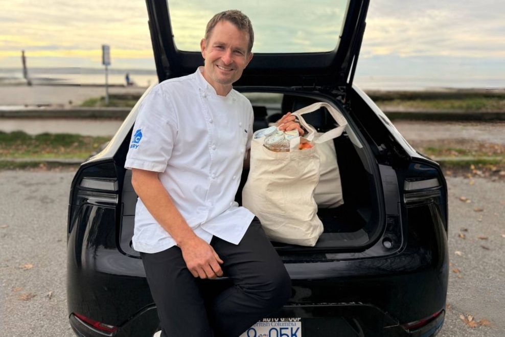 Ned sits in the hatch of his Toyota hybrid with a bag of groceries.