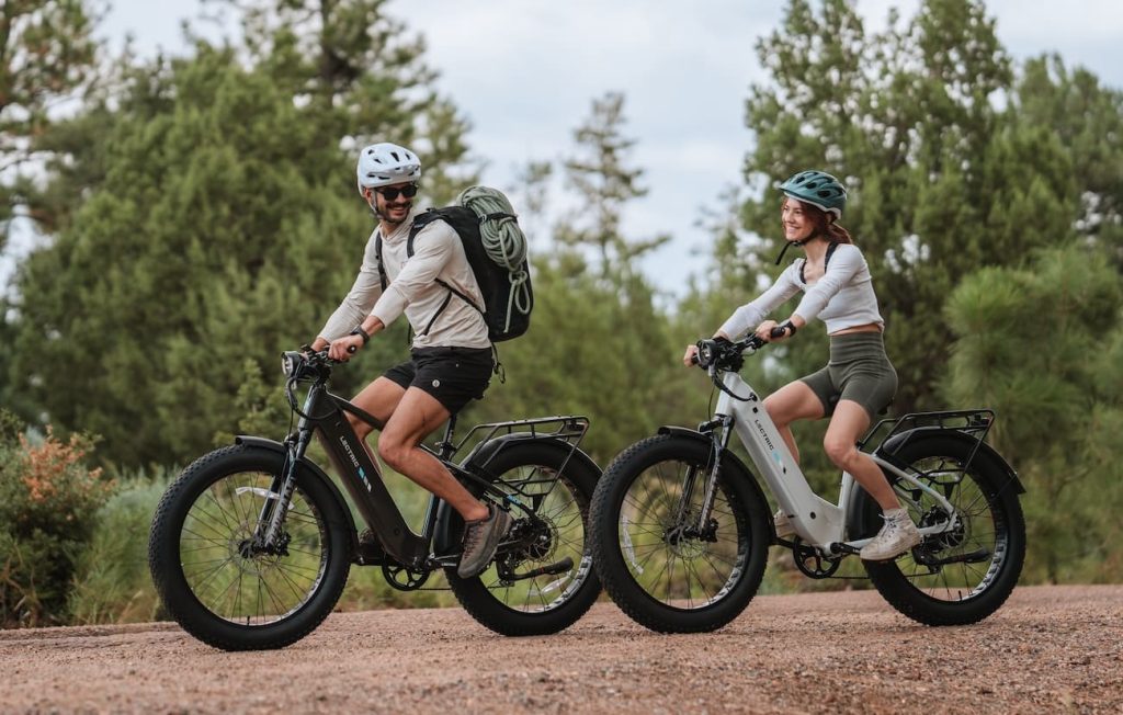 man and woman riding Lectric XPeak 2.0 e-bikes down trail