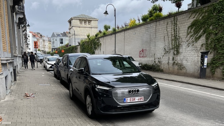 A black Audi Q4 E-Tron parked along a brick sidewalk.