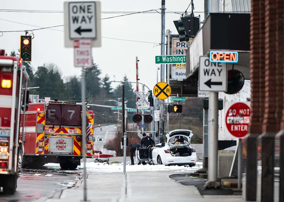 Tacoma police investigate the scene where a driver crashed into a traffic-signal pole, causing life-threatening injuries to the driver and killing a woman in the passenger seat at the intersection of South 56th Street and Washington Street in Tacoma on Jan. 7, 2023. 
