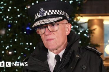 BBC Sir Mark Rowley in uniform outside New Scotland Yard in London. Behind him is an illuminated Christmas tree.