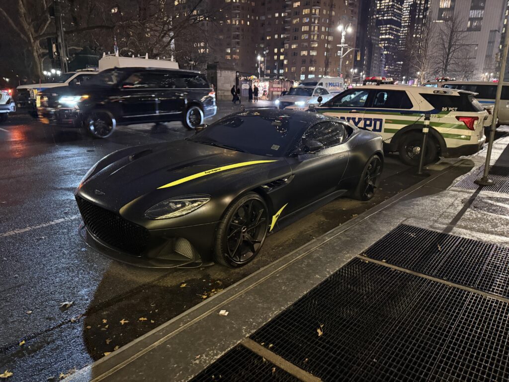 An [Aston Martin DBS Superleggera] parked in the rain at Columbus Circle.