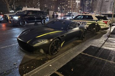 An [Aston Martin DBS Superleggera] parked in the rain at Columbus Circle.