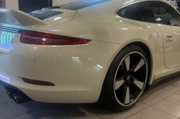 [2014 Porsche 911 50th Anniversary Edition] in Geyser Grey Metallic with Fuchs retro wheels in the workshop.