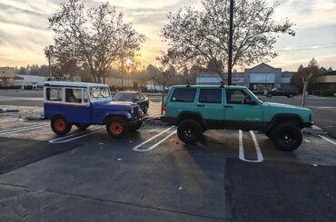 Ex forest service XJ Cherokee flat towing a '75 DJ5. Official cars of?