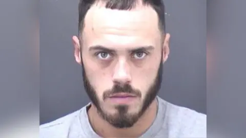 Dorset Police Custody picture of Jonjay Harrison, 25 wearing a grey sweatshirt