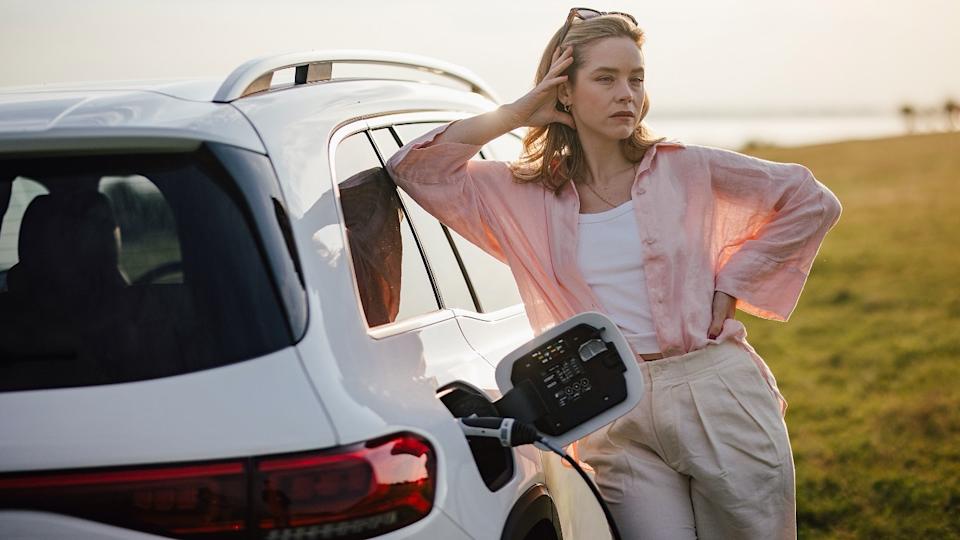 Woman waiting for her electric car to charge