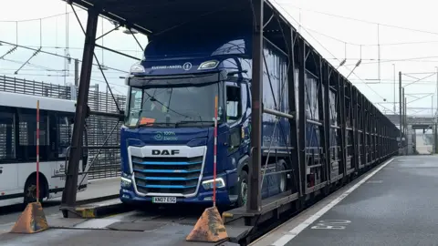 BBC A blue HGV is parked on a freight train