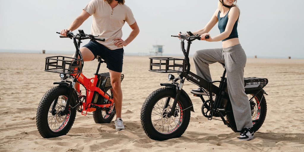 man and woman riding Heybike Mars 2.0 e-bikes on beach