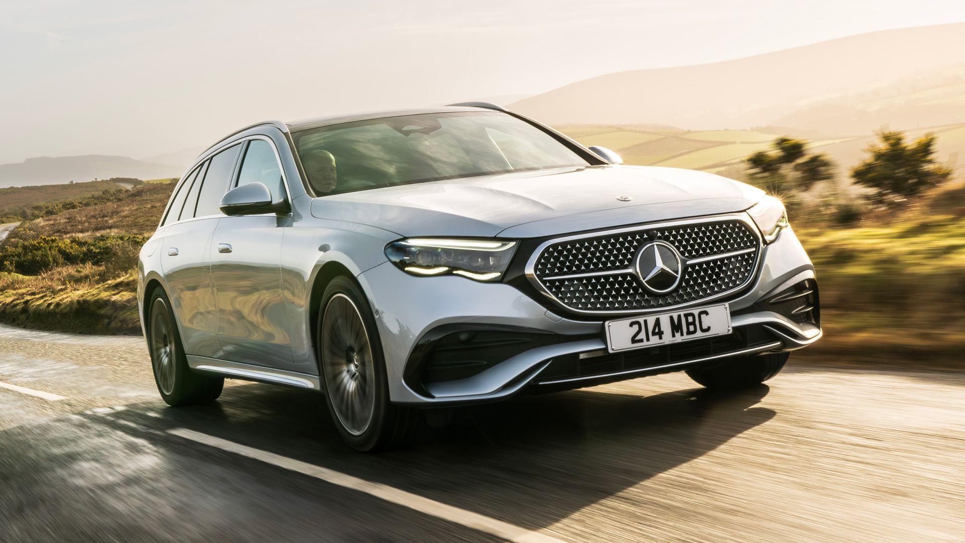A silver Mercedes-Benz E-Class estate driving along sunny rural road.