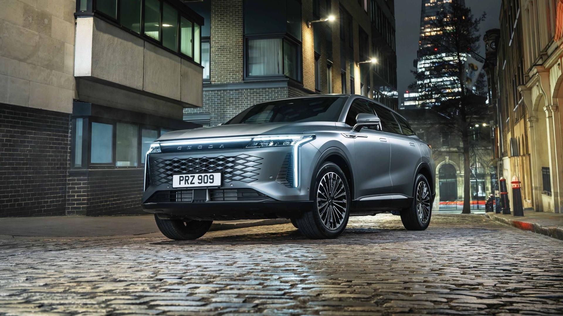 A grey Omoda 9 parking on a cobbled street in an urban area.