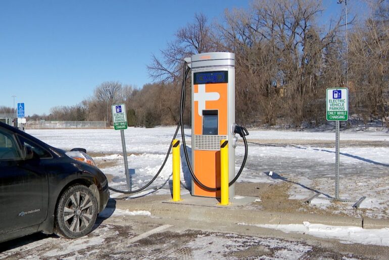 a sign in a parking lot noting where electric vehicles can park