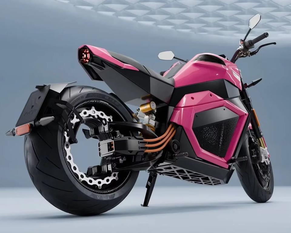 Pink and black electric motorcycle with thick rear tire and exposed orange cables.