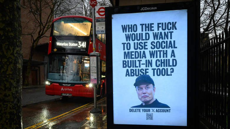 LONDON, ENGLAND - JANUARY 13: (EDITORS NOTE: Image contains profanity) An unofficially-installed poster picturing Elon Musk with the tagline, "Who the [expletive] would want to use social media with a built-in child abuse tool?" is displayed on a bus shelter on January 13, 2026 in London, England. Yesterday the UK communications regulator Ofcom launched a formal investigation into Elon Musk's social media platform X, regarding its AI chatbot, Grok. The probe centers on reports that Grok has been used to generate non-consensual sexual deepfakes, including "undressed" images of women and sexualized images of children. The activist group Everyone Hates Elon has created a series of posters and public artworks in recent months critical of Elon Musk, as well as other business and political leaders.