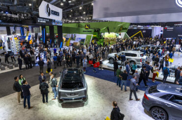 Several cars with components by Gentex Corporation are viewed as attendees also walk about a GW ...