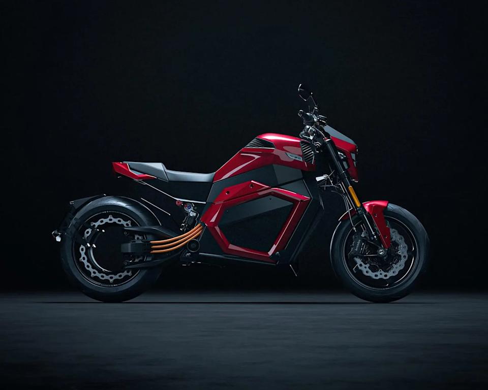 Red and black electric motorcycle with exposed orange cables and disc brakes on a dark background.