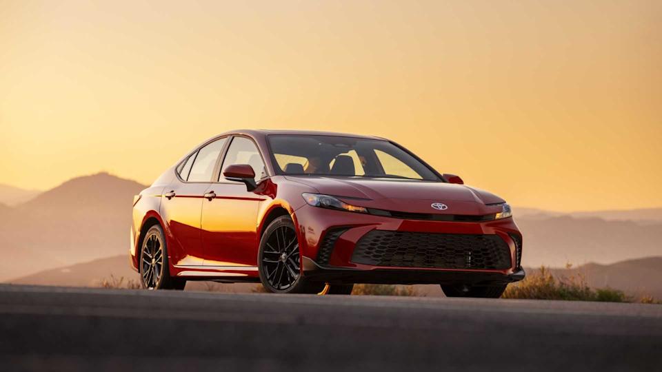 Front 3/4 view of a red 2025 Toyota Camry with mountains in the background.