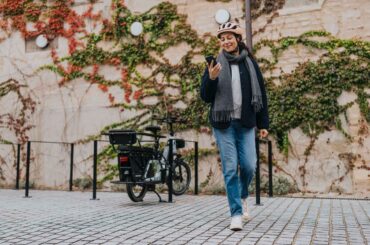 Woman walking away from her ebike parked in a bike rack.