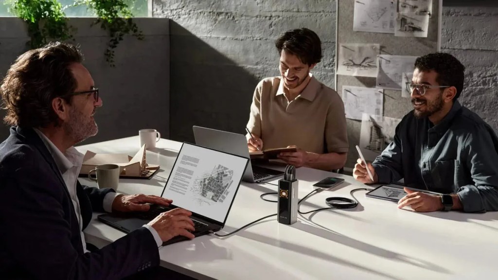 three men using EcoFlow power bank in office with laptops and tablet