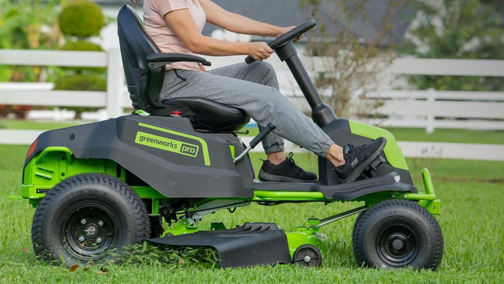 woman mowing lawn with greenworks riding lawn mower