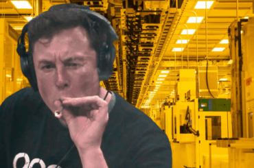 A person wearing headphones holds a cigar-like object inside an industrial facility with yellow lighting.