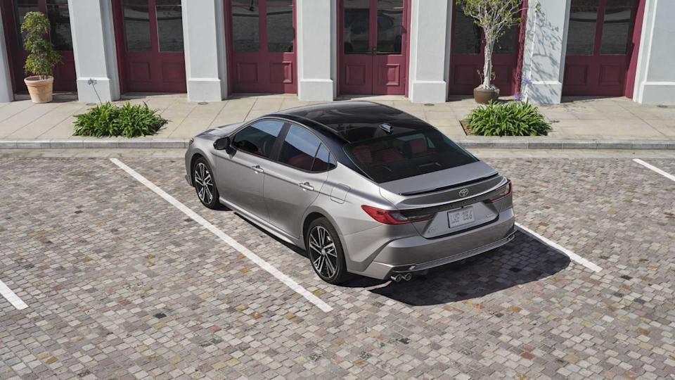 Rear 3/4 shot of a gray 2025 Toyota Camry XSE parked outside of a building.