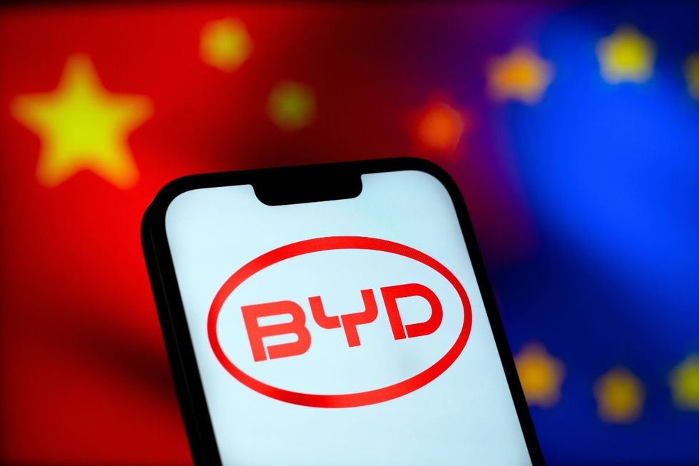 Chinese and EU flag in the background, with a BYD logo in front
