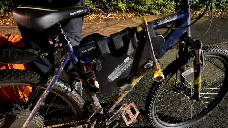Confiscated modified e-bike photographed from side with police officer in view