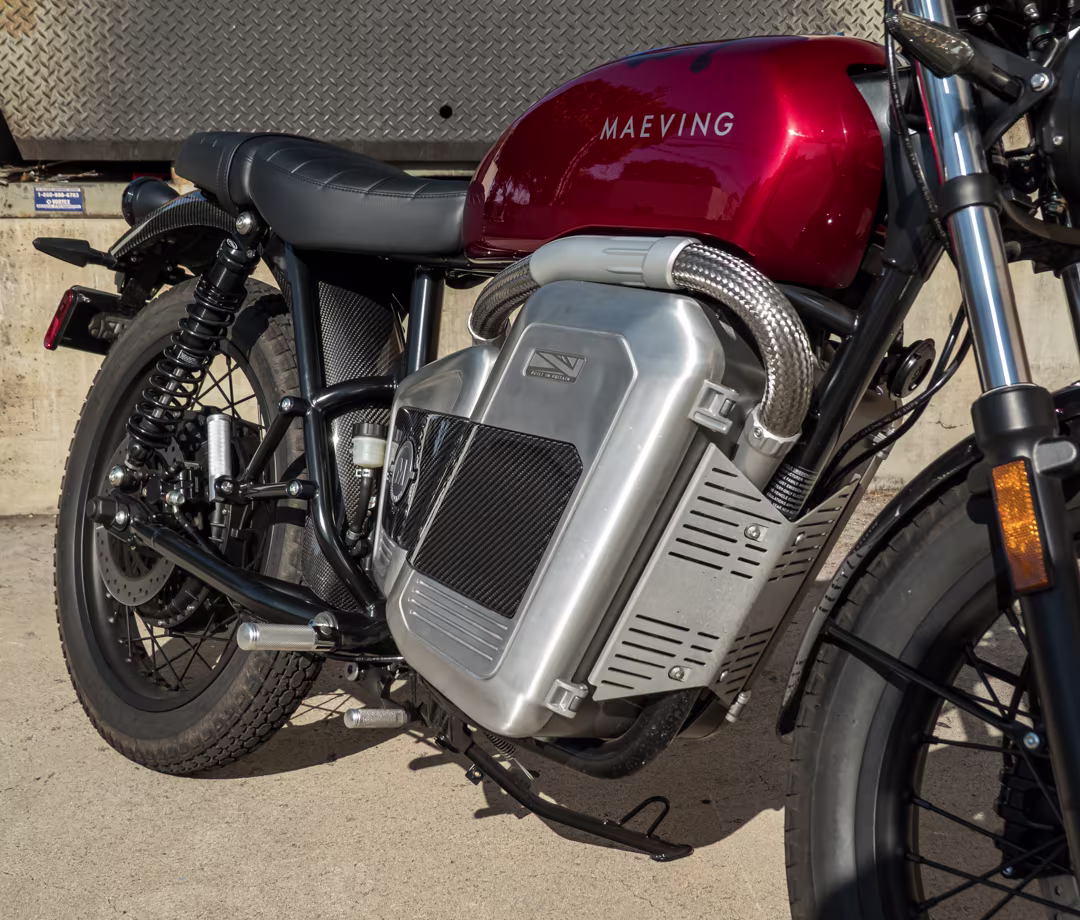 Red Maeving RM2 electric motorcycle battery compartment detail, part of Men's Journal tested motorcycle reviews.