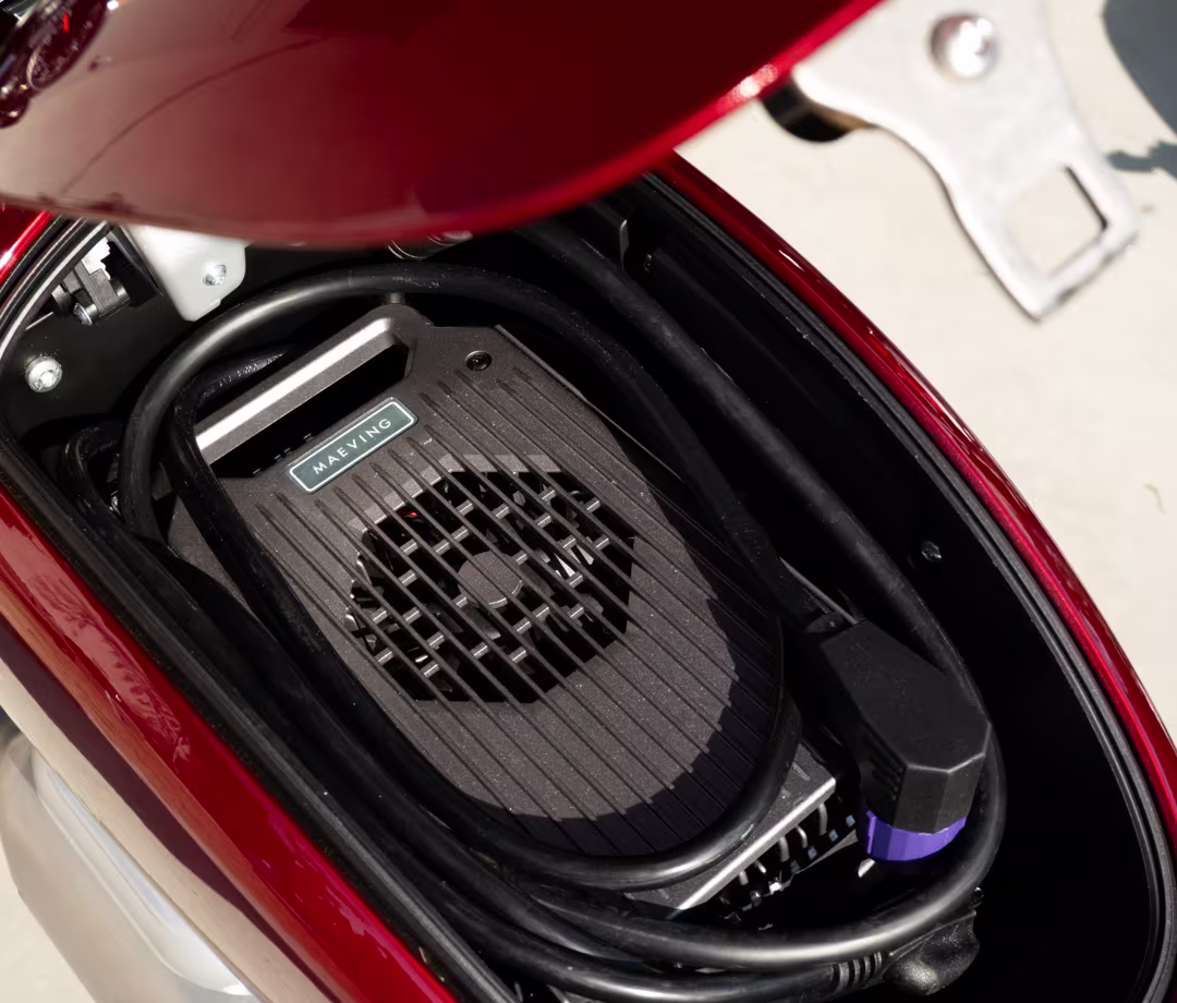 Red Maeving RM2 electric motorcycle storage compartment detail, part of Men's Journal tested motorcycle reviews.