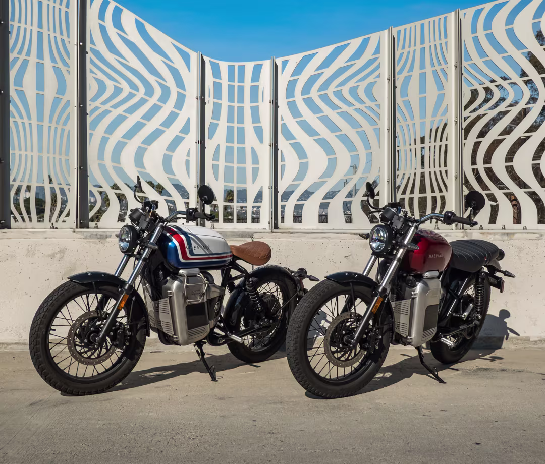 Red Maeving RM2 electric motorcycle and red, white and blue RM1, part of Men's Journal tested motorcycle reviews.