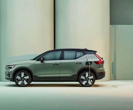 A green Volvo XC40 Recharge SUV is charging. 