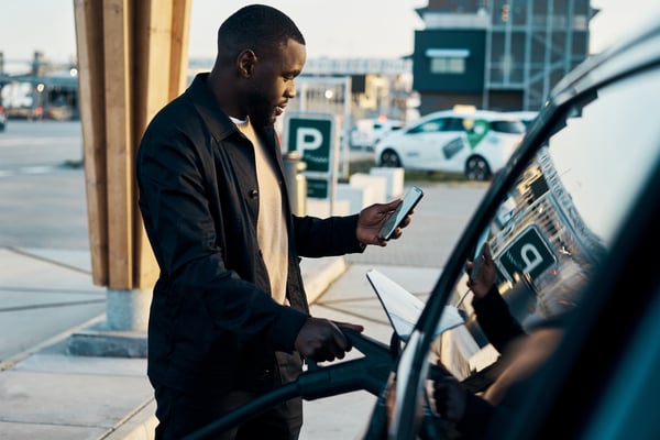 A man plugging in his electric vehicle.