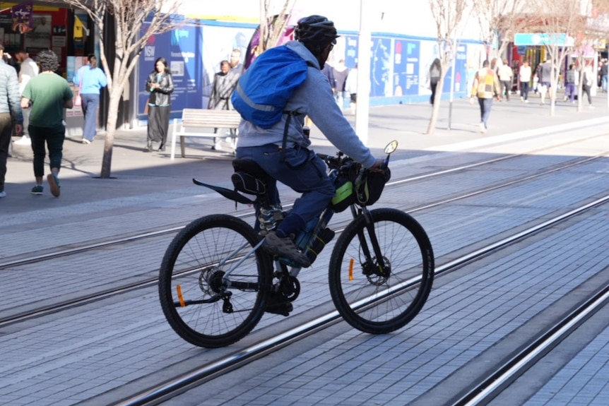 Photos of an e-bike, some delivery food e-bikes, in the Parramatta CBD on a sunny day.