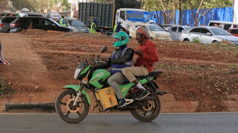 Men ride an electric motorcycle in Nairobi, Kenya, Thursday, Jan....