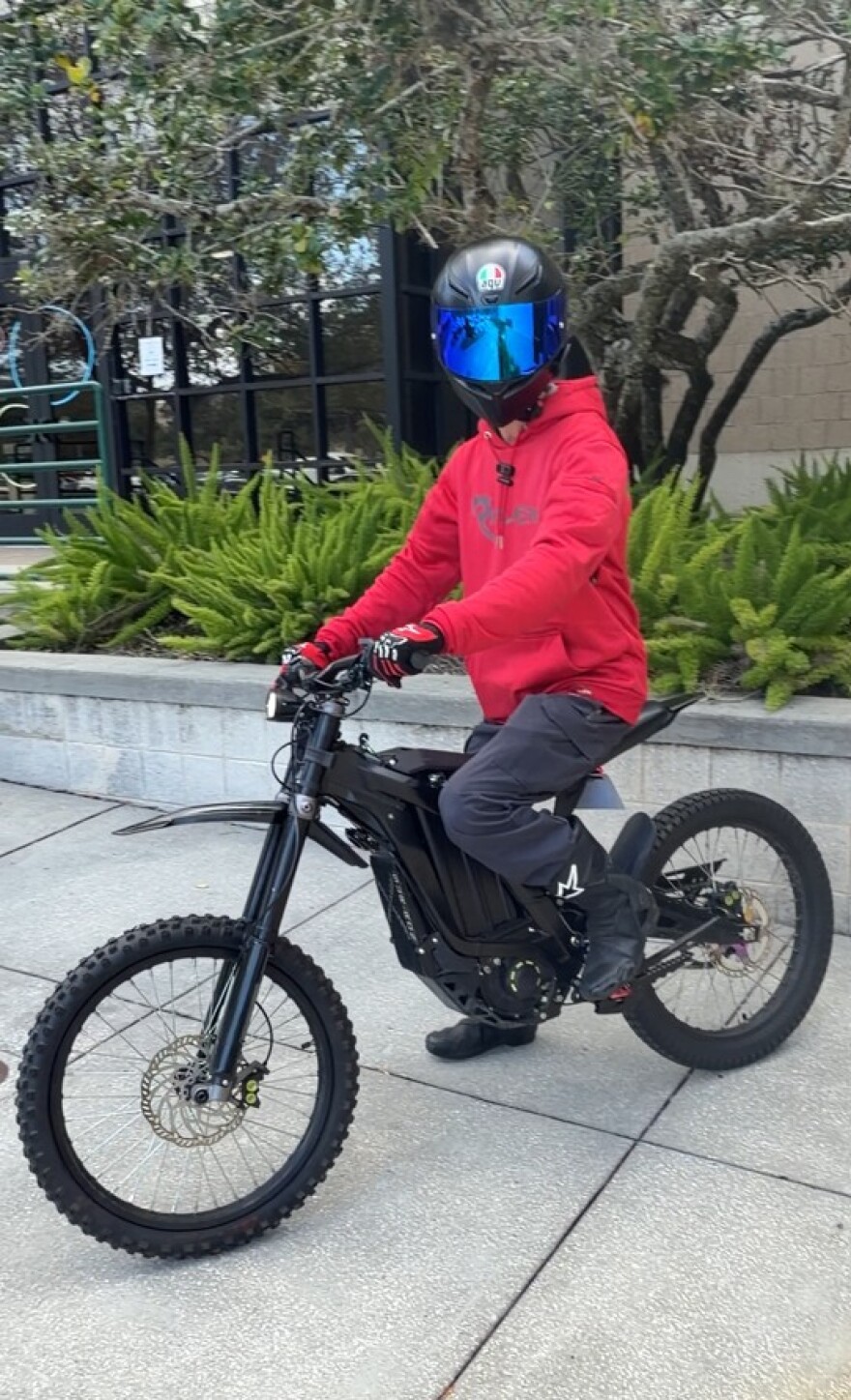 Guy in red sweatshirt on his ebike with helmet on 