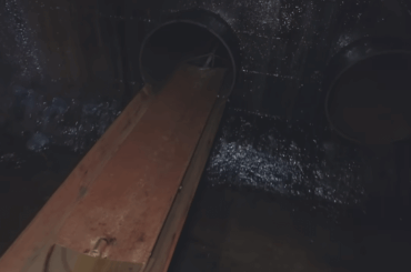 The only way in and out of the Inchindown Oil Tanks in Scotland. Workers had to push themselves on a wheeled board down a track and through a pipe.