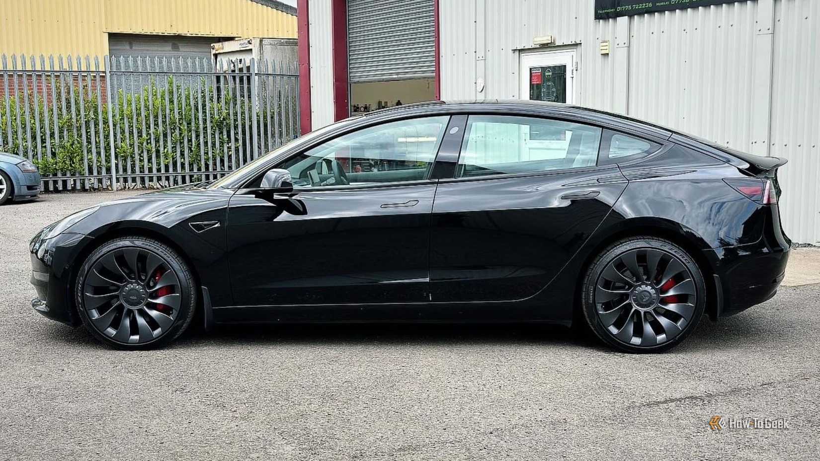 Static side profile shot of a black 2021 Tesla Model 3 Performance.