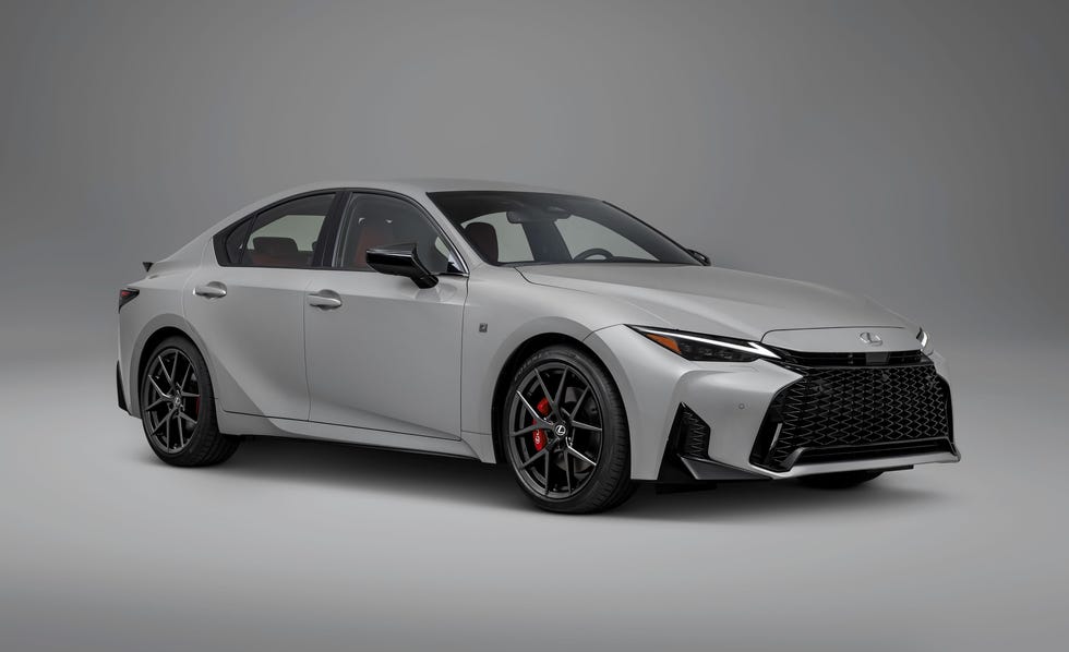 2026 Lexus IS350 front three quarter view of silver sedan with black wheels, red brake calipers, and black grille on gray background.
