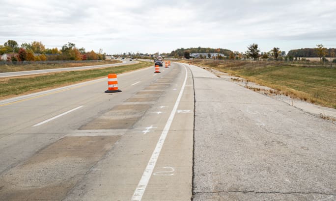 Modified highway lane with construction barrels marking a test section used for wireless charging research.