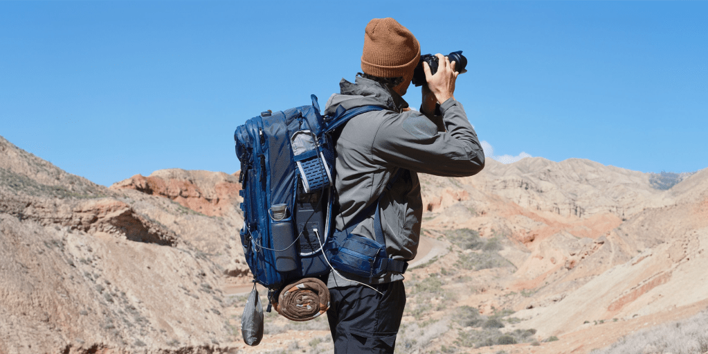 man taking picture with camera wearing Bluetti Handsfree backpack power station