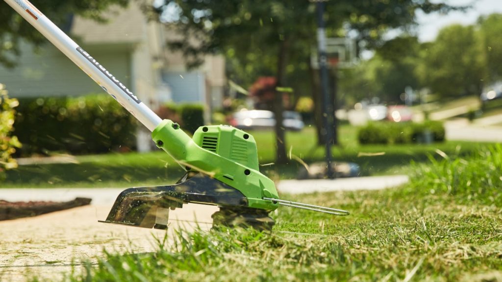 greenworks cordless electric string trimmer being used in yard